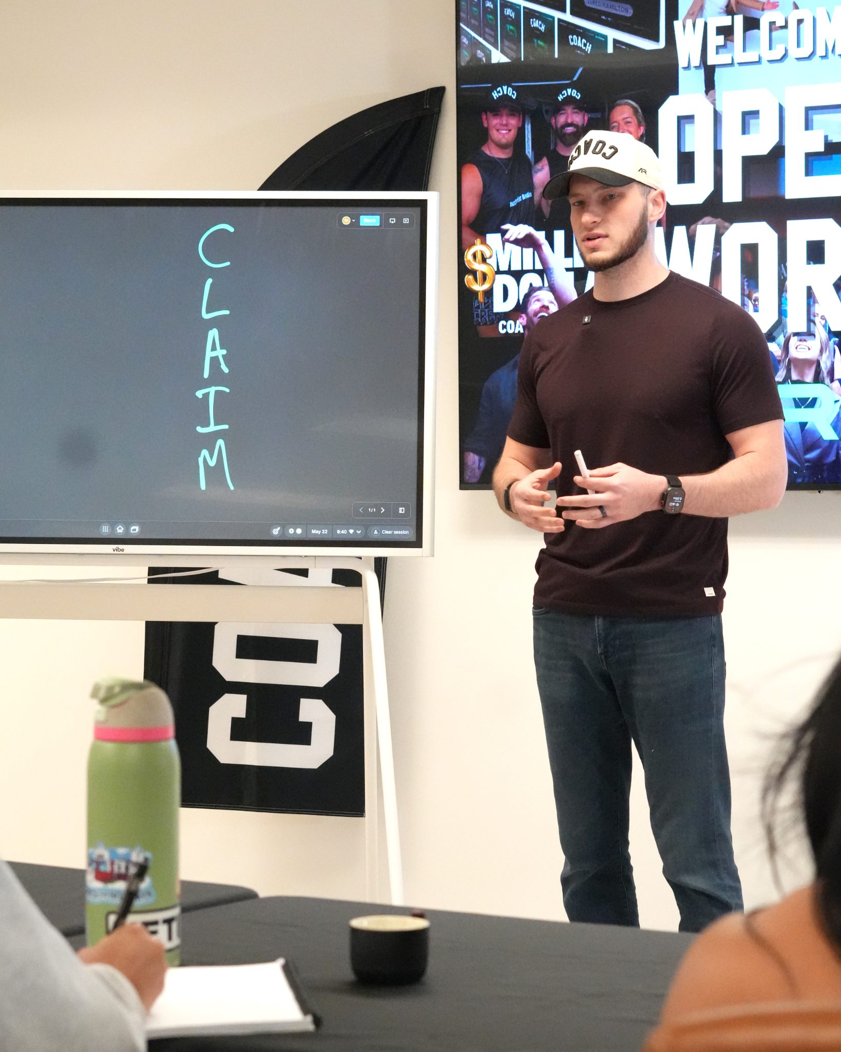 A coach presenting beside a whiteboard with one word written on it