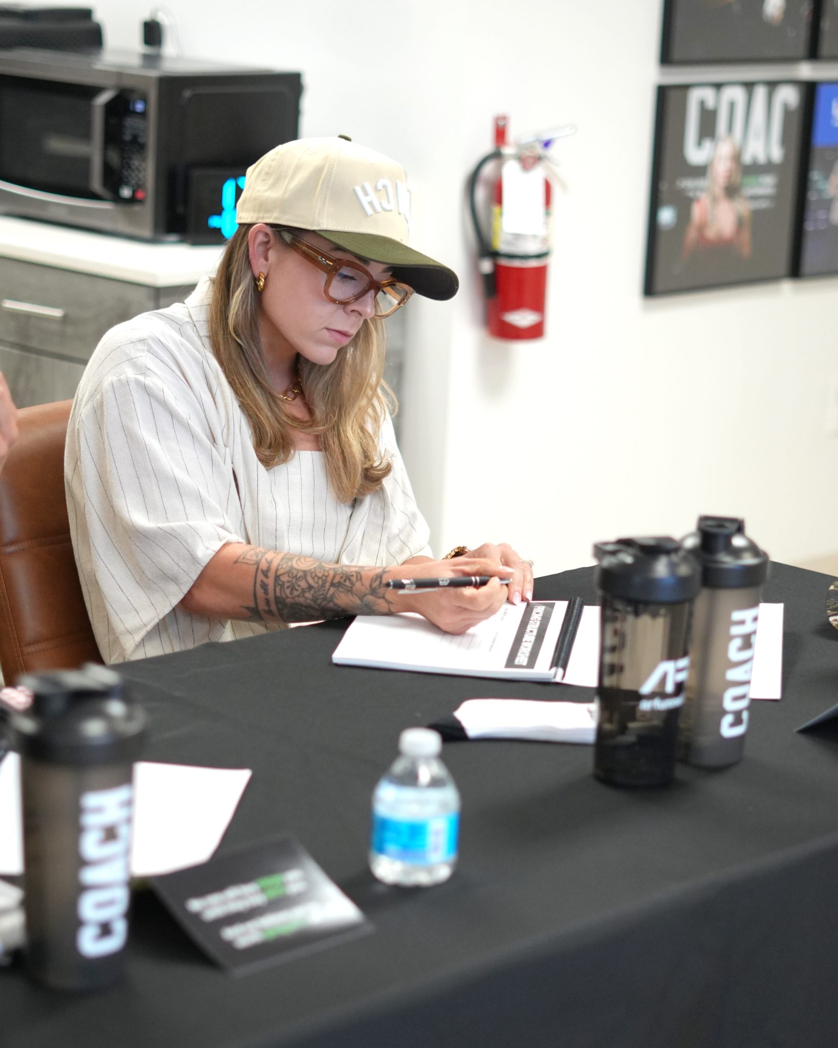 A coach writing at a table set with COACH bottles